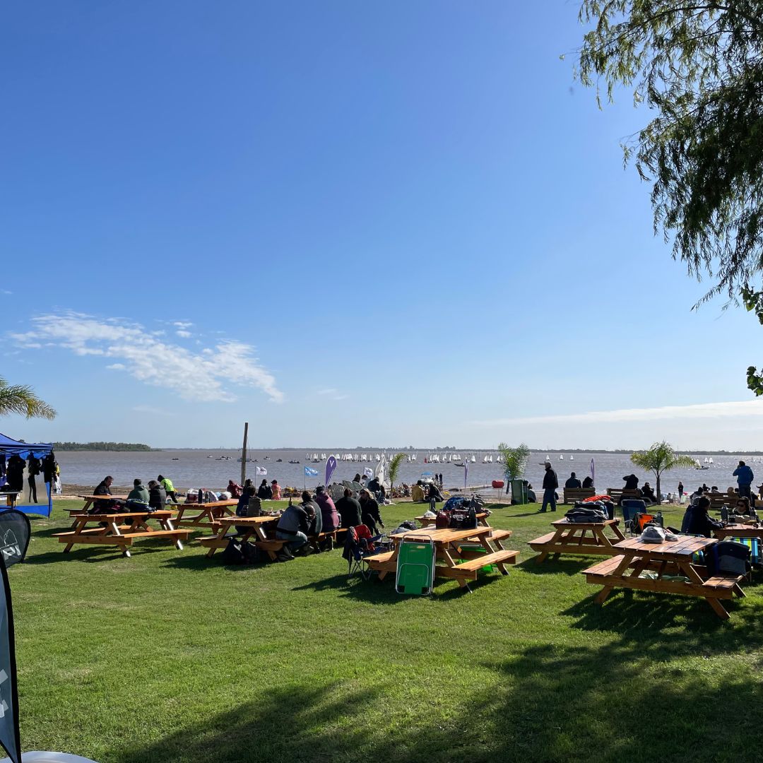 Zona de recreo en tierra, con bancos y mesas para merendar o descansar