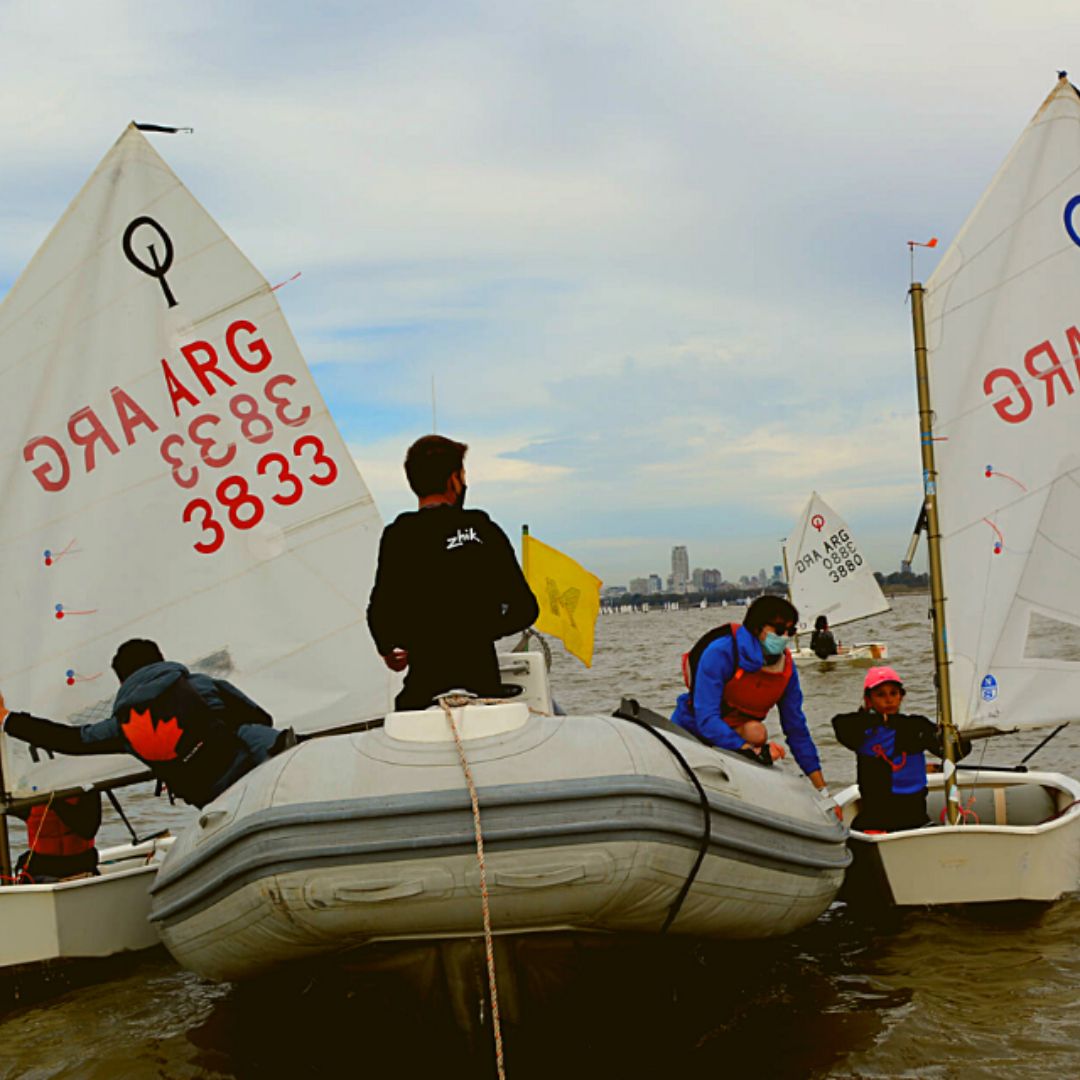 Embarcación de medición durante el selectivo al mundial de Optimist con medidor y competidores en el proceso de medición